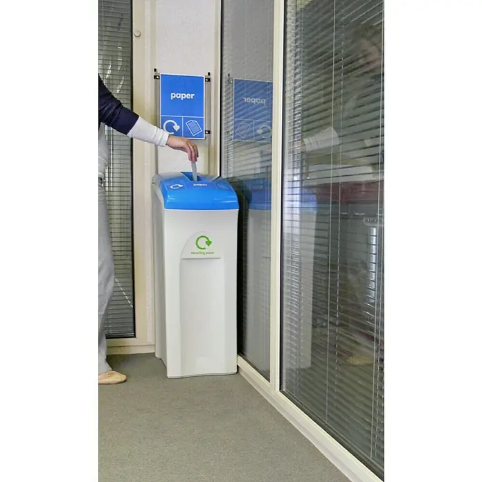 Proregal Standard-Mülleimer Wertstoffsammler Envirobin - 82 l, Kunststoff, Grau - Eine Person wirft Papier in einen weißen Recyclingbehälter mit blauem Deckel und dem Aufdruck "Recycling Point".