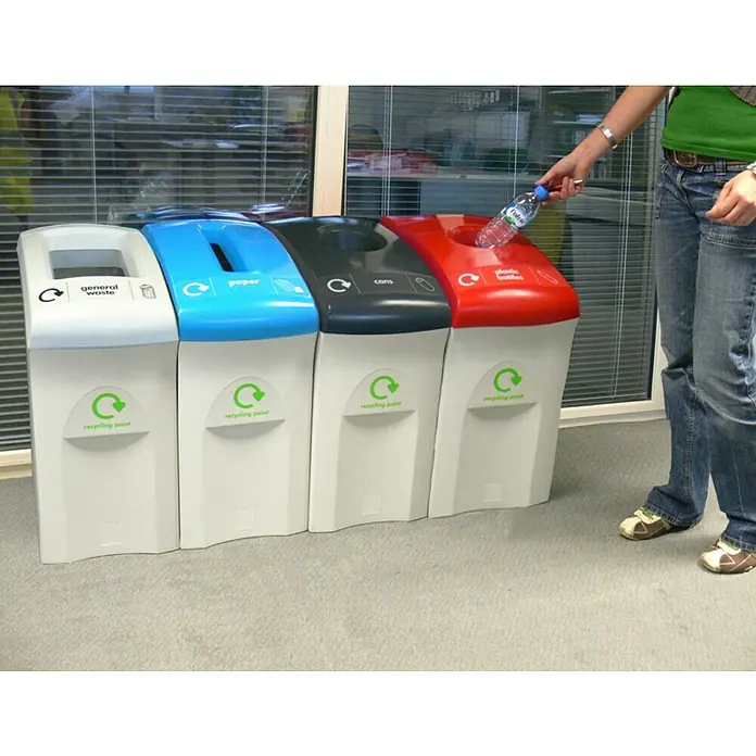 Proregal Standard-Mülleimer Wertstoffsammler Envirobin - 55 l, Kunststoff, Grau - Eine Person wirft eine Plastikflasche in einen der farblich gekennzeichneten Recyclingbehälter für Plastikflaschen in einem Büro.