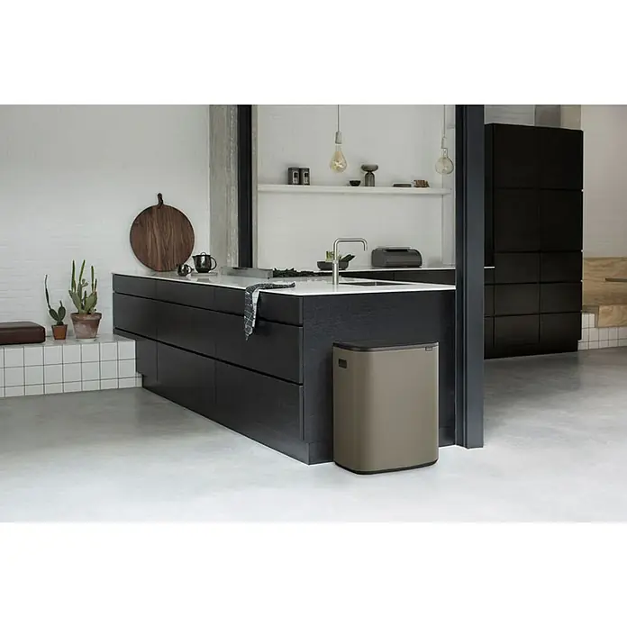 Proregal Sensormülleimer Brabantia Hochwertiger Abfallsammler mit Touch-Öffnung - 60 l, Metall, Platin - Ein stilvoller, rechteckiger Brabantia-Mülleimer in neutralem Farbton steht in einer modernen Küche mit dunklen Schränken und weißen Arbeitsplatten.