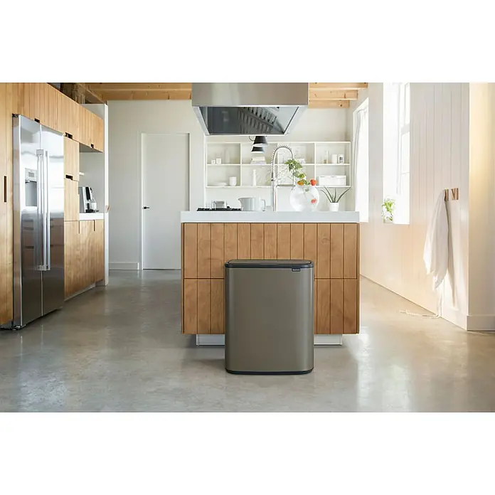 Proregal Sensormülleimer Brabantia Hochwertiger Abfallsammler mit Touch-Öffnung - 60 l, Metall, Platin - Ein stilvoller, rechteckiger Abfalleimer von Brabantia steht in einer modernen Küche mit Holzakzenten und Edelstahlgeräten.