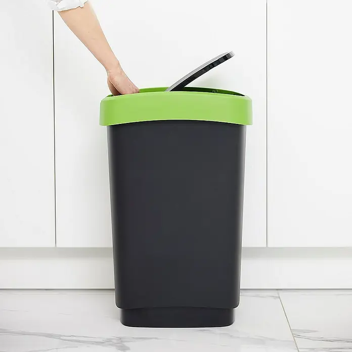 Proregal Standard Mülleimer Klassischer Abfalleimer für Innenbereich - 50 l, Kunststoff, Schwarz-Grün - Ein grauer Mülleimer mit grünem Deckel wird von einer Hand geöffnet, um Abfall zu entsorgen. Praktisch und hygienisch für den Haushalt.