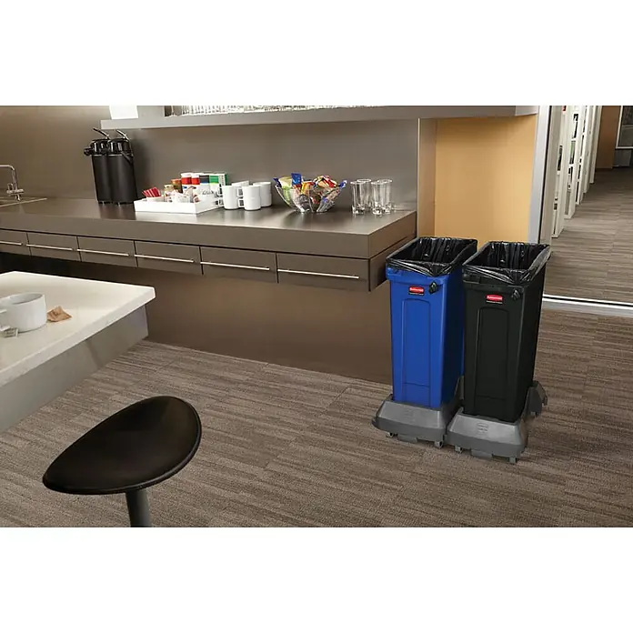Proregal Standard-Mülleimer Rubbermaid Slim Jim Mülleimer mit Belüftungskanälen - 87 l, Kunststoff, Schwarz - Zwei Rubbermaid Müllcontainer in Blau und Schwarz, beide mit schwarzen Müllsäcken, stehen auf einem Teppichboden in einem Büro.