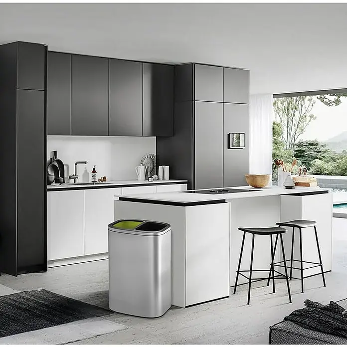 Proregal Standard-Mülleimer - 40 l, Edelstahl, Silber - Ein moderner, silberfarbener Abfallbehälter mit zwei Fächern, der in einer stilvollen Küche steht. Praktische Mülltrennung leicht gemacht.