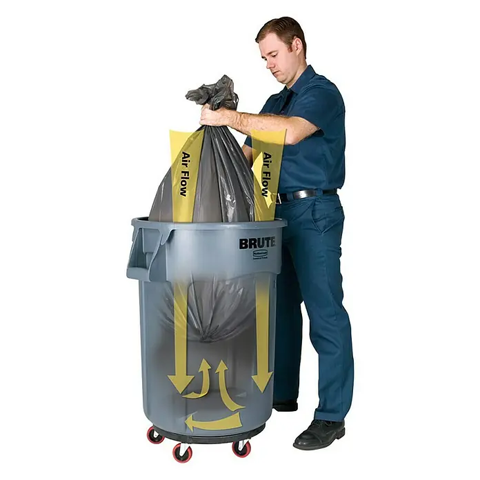 Proregal Standard-Mülleimer Rubbermaid Brute runde Mehrzwecktonne mit Belüftungskanälen - 166,5 l, Kunststoff, Grau - Ein Mann setzt einen Müllsack in einen grauen Brute-Mülleimer mit Luftstrom-Design. Die Luft kann entweichen und das Einsetzen des Müllsacks erleichtern.