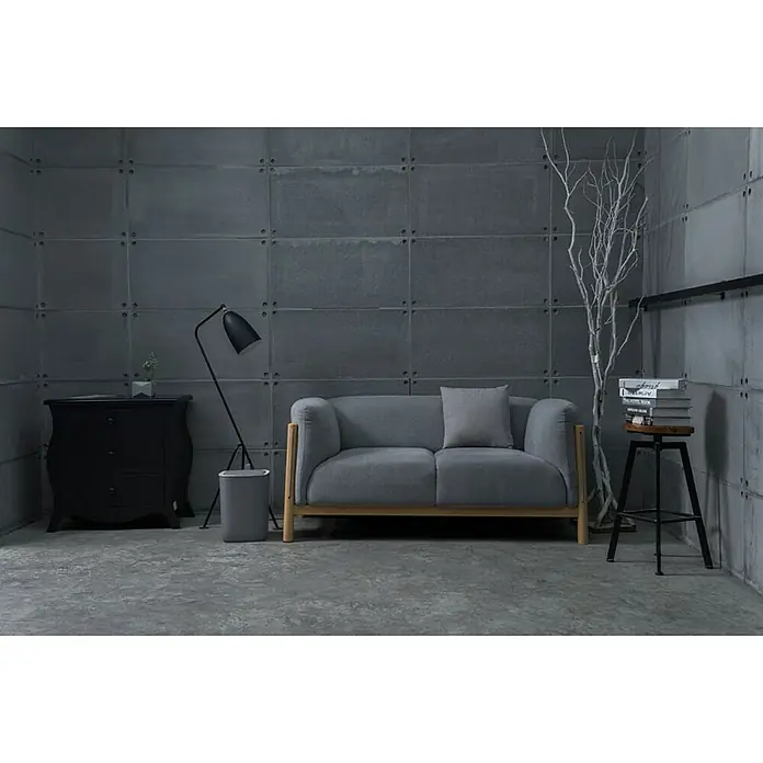 Proregal Sensormülleimer Moderner quadratischer Abfalleimer mit Smart Sensor - 12 l, Kunststoff, Grau - Graues Sofa mit Holzbasi in einem industriellen Raum. Eine Stehlampe und ein Hocker sind neben dem Sofa, die eine gemütliche Atmosphäre vermitteln.