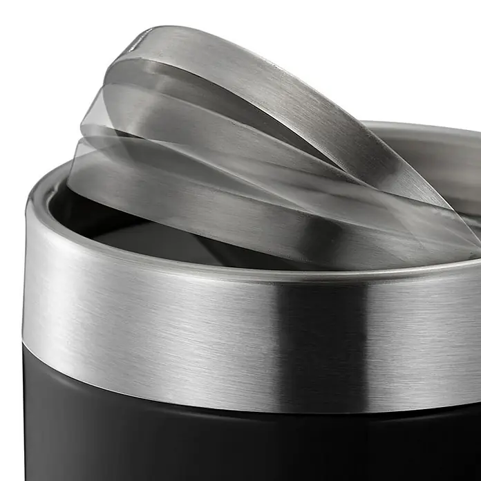 Proregal Schwingdeckeleimer Schön geformter Tischabfallbehälter mit Flachschwingdeckel - 1,5 l, Edelstahl, Edelstahl / Schwaru - Detailaufnahme eines schwarzen Mülleimers mit schwingendem Edelstahldeckel, der teilweise geöffnet ist. Das Metall ist gebürstet.