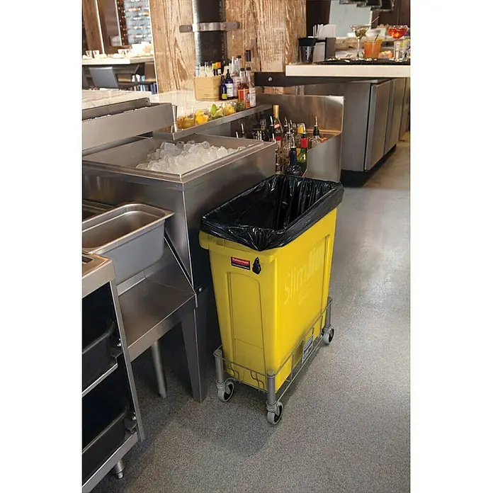 Proregal Standard-Mülleimer Rubbermaid Slim Jim Mülleimer mit Belüftungskanälen - 87 l, Kunststoff, Gelb - Gelber Slim Jim Müllcontainer von Rubbermaid auf einem Wagen mit schwarzem Müllsack in einer gewerblichen Küche.
