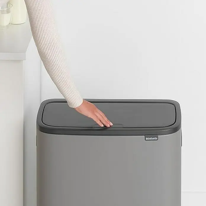 Proregal Sensormülleimer Brabantia Hochwertiger Abfallsammler mit Touch-Öffnung - 60 l, Metall, Grau - Eine Person öffnet den Deckel eines grauen Brantia-Mülleimers. Der Mülleimer hat ein schlankes, rechteckiges Design und ist für den Innenbereich geeignet.