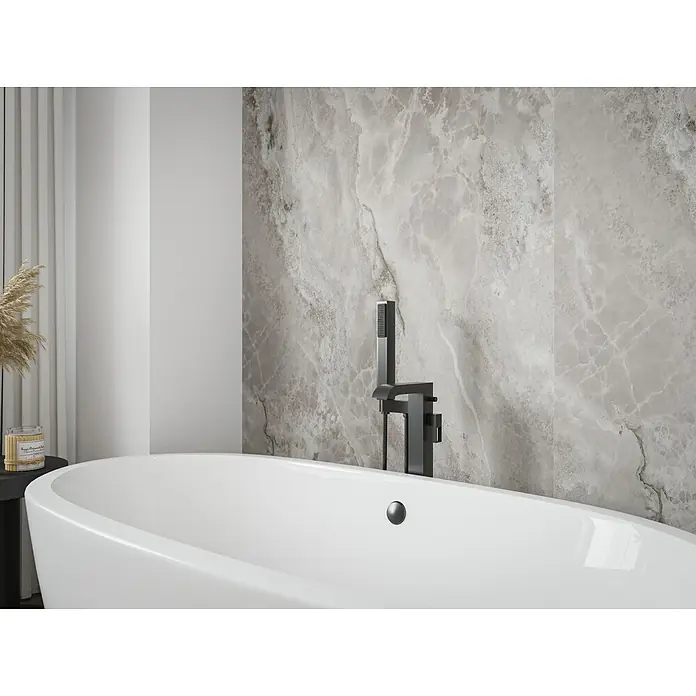 Wetwall Wandpaneel Elite - 16 x 242 cm, Onyx Grey, Abgerundete Kante - Nahaufnahme einer modernen Badewanne mit schwarzer Armatur vor einer grauen Marmorwand. Elegantes Baddesign mit Fokus auf die Badewanne.