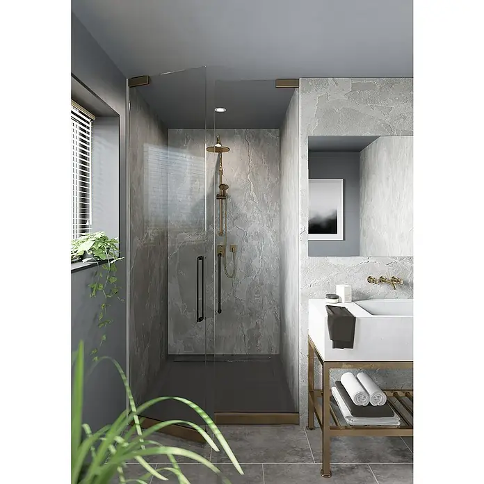 Wetwall Wandpaneel Elite - 16 x 242 cm, Scafell Slate, Abgerundete Kante - Ein modernes Badezimmer mit einer ebenerdigen Dusche mit Glaswänden und stilvoller Armatur, ergänzt durch einen Waschtisch mit goldenem Gestell.