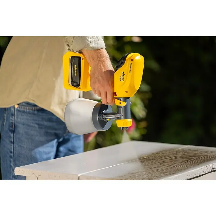 Wagner Akku-Farbsprühsystem Wood&Metal Sprayer W 250 18V - 18 V, Ohne Akku - Nahaufnahme einer Wagner Farbspritzpistole in Aktion. Ideal für Heimwerkerprojekte mit gleichmäßigem Farbauftrag, dank moderner Technologie.