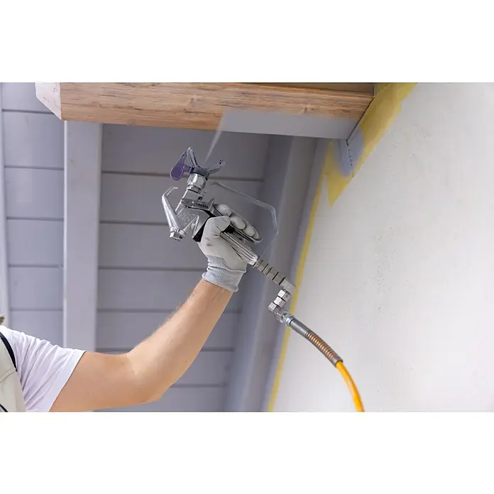 Akku-Farbsprühsystem - 18 V, 1 Akku, 4 Ah, Max. Fördermenge: 0,9 l/min - Lackierpistole in Aktion: Ein Handwerker sprüht mit einer Farbpistole eine Decke, um eine gleichmäßige Beschichtung zu erzielen, ideal für Renovierungsarbeiten.
