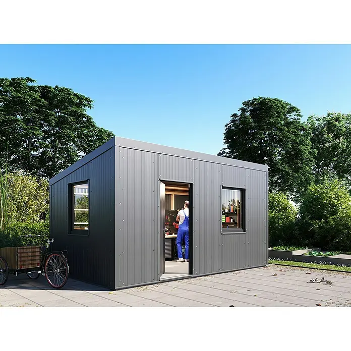 Fassadenpaneel Sandwich PUR - Anthrazit, L x B: 250 x 100 cm, Stahl - Ein modernes graues Gartenhaus mit Fenster und offener Tür, umgeben von Grünpflanzen und einem klaren blauen Himmel.