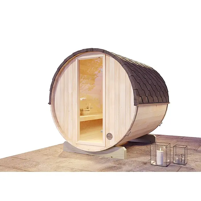 FinnTherm Fasssauna Mini S - Holz - Eine Fasssauna mit Glastür und Schindeldach steht auf einer Terrasse, neben zwei Windlichtern mit Kerzen.