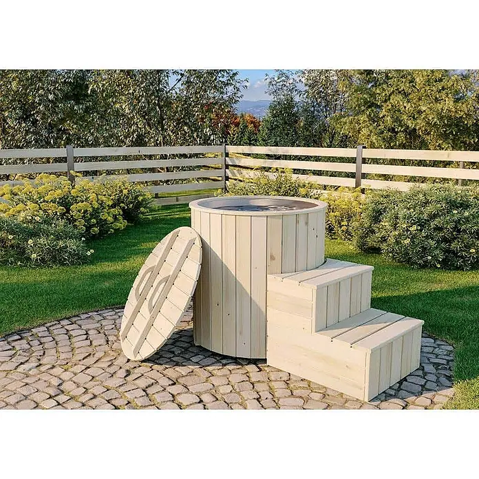 FinnTherm Hot Tub Cold Tub - Nordische Holz, Naturbelassen - Diese Aufnahme zeigt einen hölzernen Badezuber mit Treppe und Deckel in einer Gartenumgebung. Der Zuber steht auf einem gepflasterten Bereich.