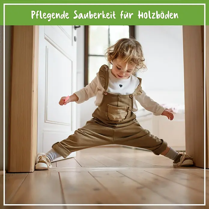 Poliboy Bio Reinigungsmittel Parkett und Holzdielen - 1 l, Flasche - Eine niedliche Bild von Mädchen, das auf einem sauberen Holzboden spielt. Die strahlende Sauberkeit des Bodens betont die Reinheit.