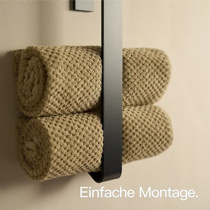 Designfabrik Hamburg Handtuchhalter - Schwarz - Nahaufnahme eines stilvollen, schwarzen Handtuchhalters mit zwei gerollten, beigen Handtüchern, die eine elegante Badgestaltung betonen.
