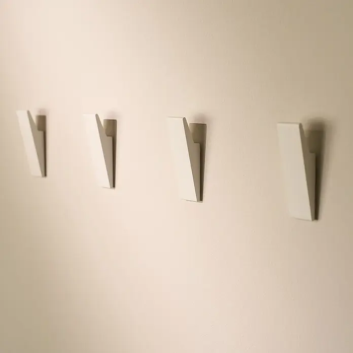 Designfabrik Hamburg Handtuchhaken - 4 Stk., Weiß, Matt - Wandansicht mit vier weißen, modernen Kleiderhaken an einer hellen Wand, die ein minimalistisches und stilvolles Design betonen.