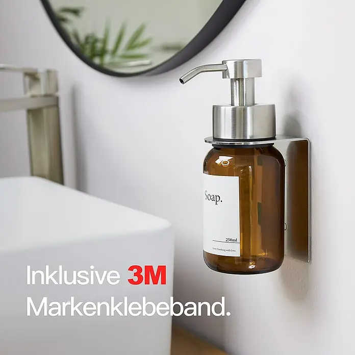 Designfabrik Hamburg Seifenspender - Edelstahl, Silber/Braunglas, Wandmontage - Brauner Seifenspender mit silberfarbener Pumpe und Halterung an einer weißen Wand, inklusive 3M Markenklebeband.