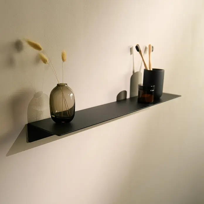 Designfabrik Hamburg Badablage - Breite: 58 cm, Aluminium, Schwarz - An der Wand montiertes Regal mit dekorativen Gegenständen. Das Regal ist schwarz und beherbergt eine Vase, eine Creme und Zahnbürsten.