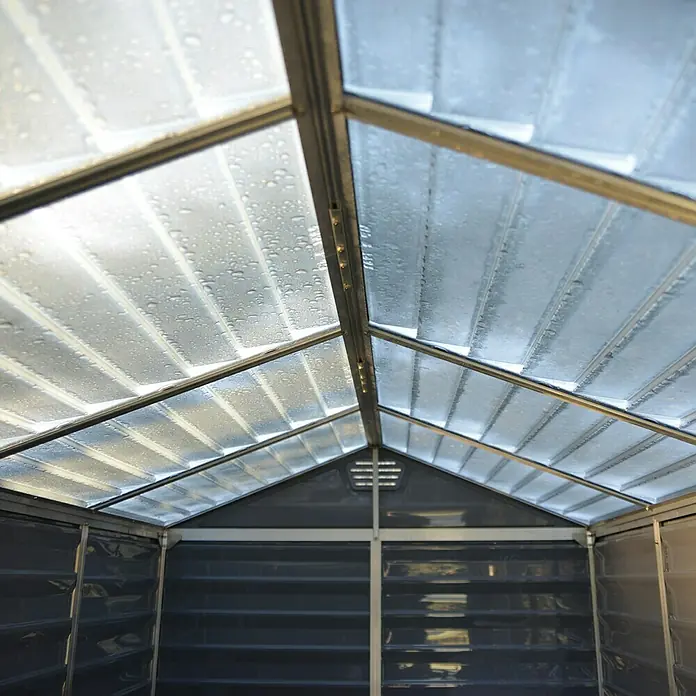 Palram – Canopia Gerätehaus Skylight 6x8 TanAußenmaß inkl. Dachüberstand (B x T): 185 x 229 cm, Kunststoff, Beige/Braun - Innenansicht eines Gewächshauses mit transparentem Dach und Metallrahmen, das Licht hereinlässt und eine kontrollierte Umgebung bietet.