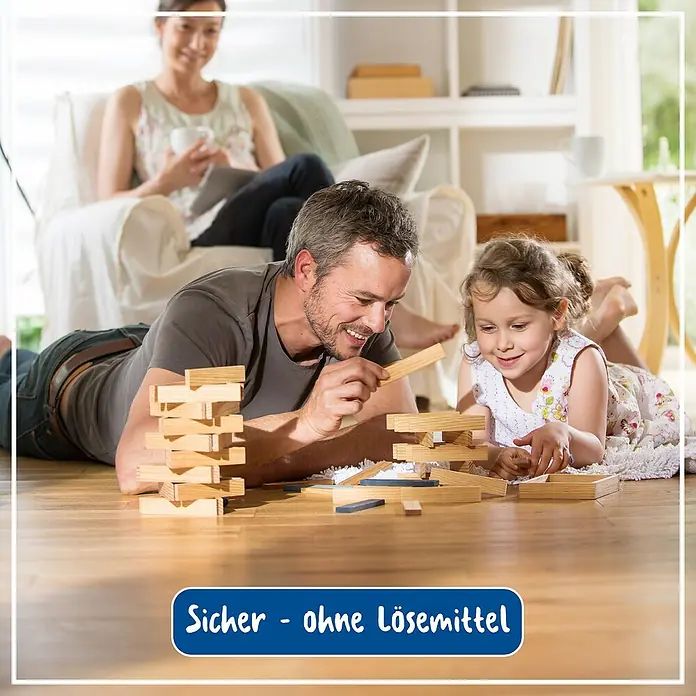 Poliboy Reinigungsmittel Laminat Renovierer - 500 ml, Flasche - Ein Vater und seine Tochter spielen mit einem Holzbauspiel auf dem Boden, während die Mutter im Hintergrund sitzt.
