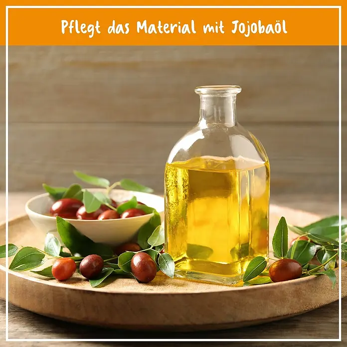 Poliboy Reinigungskonzentrat Vinyl- & Designbelag - 500 ml, Flasche - Jojobaöl in einer Glasflasche, begleitet von Jojobasamen und Blättern auf einem Holztablett. Pflegt das Material.