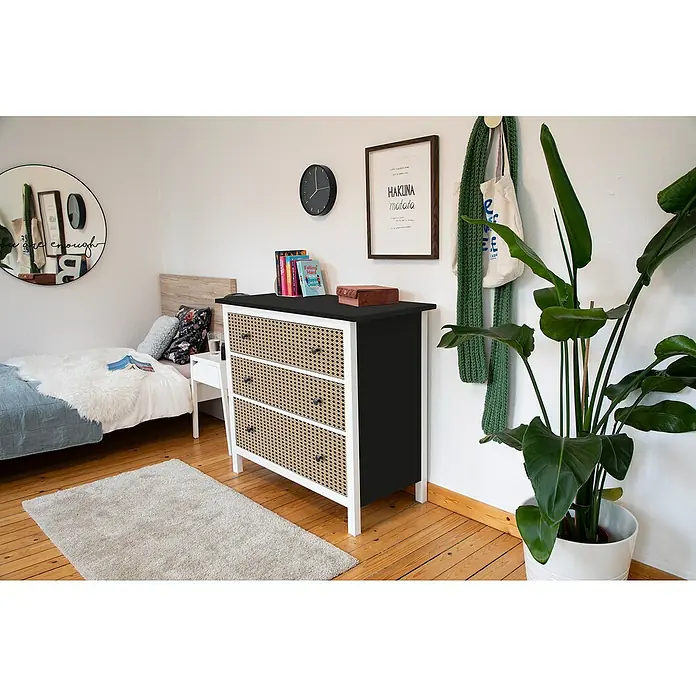 D-c-fix Klebefolie Kreativ-Kit - 3 Stk., 2 m x 67,5 cm, Uni Seidenmatt Schwarz/Woven Cane, Selbstklebend - Schlafzimmer-Szene mit einer Kommode mit Rattangeflecht-Schubladen, Büchern und einer Zimmerpflanze.