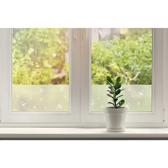 D-c-fix Static Glasfolie Wild Bees - 150 x 20 cm, Transluzent, Statisch haftend - Nahaufnahme eines Fensters mit dekorativer Fensterfolie mit Bienen- und Wabenmuster, das Privatsphäre bietet und gleichzeitig Licht durchlässt.