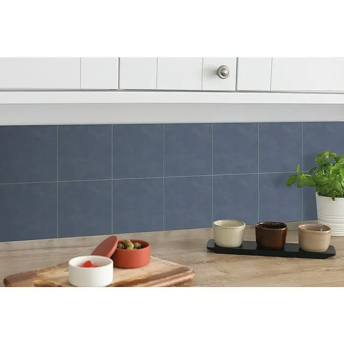 D-c-fix Fliesensticker - 6 Stk., 15 x 15 cm, Zement Blau - Küchenansicht mit blauen Fliesen-Wandpaneelen, Kräutertopf und kleinen Schalen auf einer Holzoberfläche, die eine gemütliche Atmosphäre schafft.