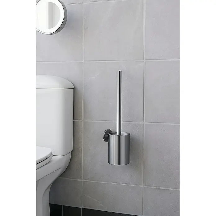 Camargue Carlit Escobillero mural - Altura: 34 cm, Black gun metal - Un escobillero moderno de acero inoxidable cuelga de una pared de azulejos gris claro, al lado de un inodoro.