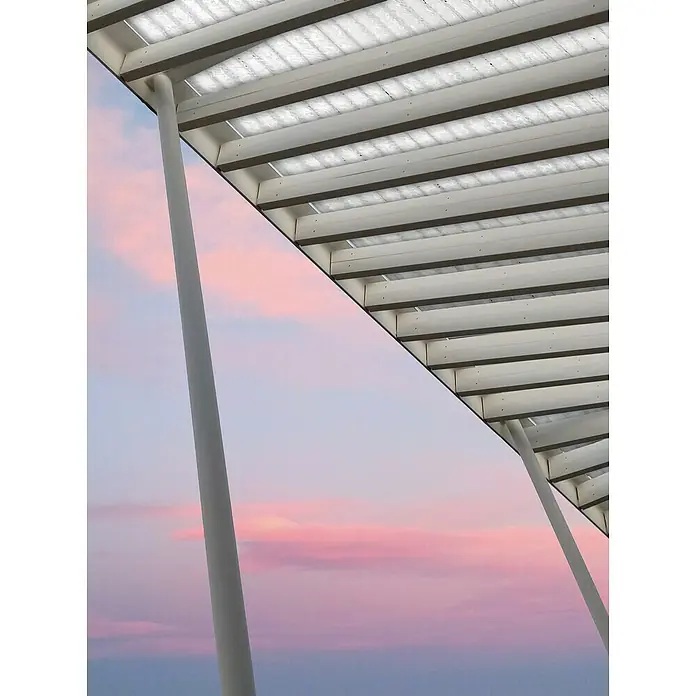 Malla sombreadora - L x Al: 5 x 4 m, Blanco, Polietileno - Estructura arquitectónica con pilares blancos y techo traslúcido contra un cielo de atardecer pastel. Diseño elegante se une a la belleza natural.
