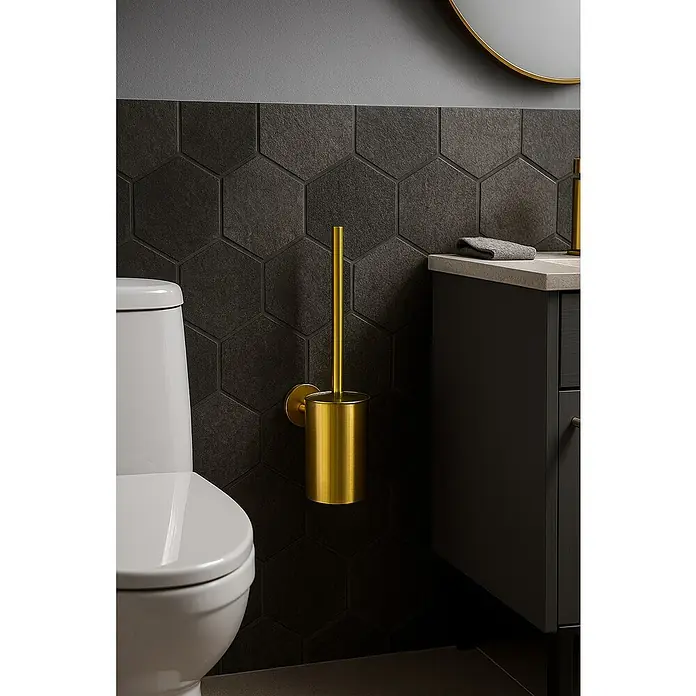 Camargue Carlit Escobillero mural - Altura: 34 cm, Oro - Primer plano de un escobillero dorado con soporte montado en una pared de azulejos hexagonales negros.