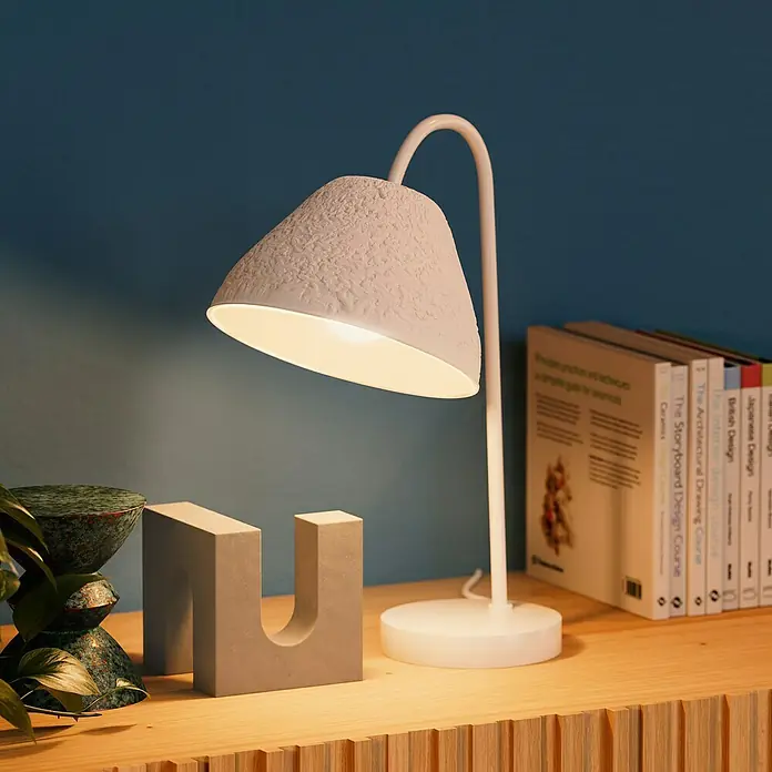 Ledvance Lámpara de sobremesa redonda Camel Bell - 40 W, Ø x Al: 33,5 x 46 cm, Blanco, E14 - Primer plano de una elegante lámpara de mesa blanca texturizada que emite un brillo cálido sobre una mesa de madera.