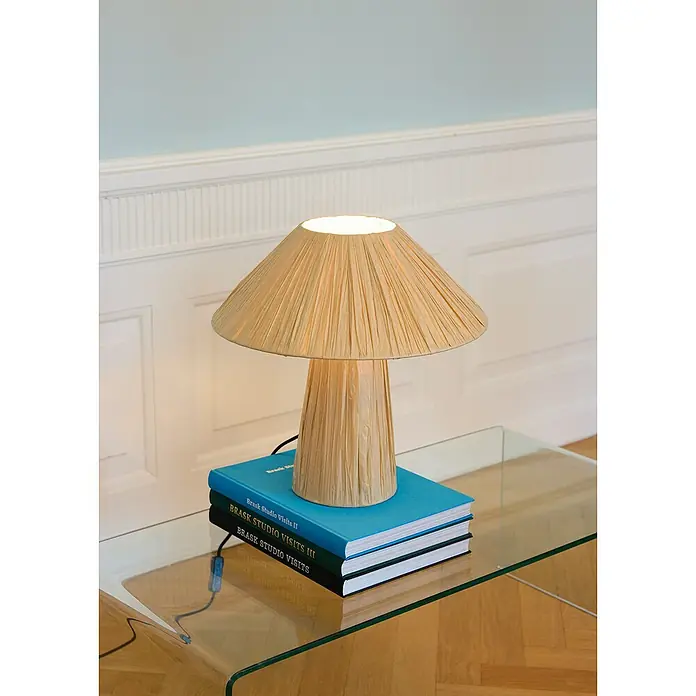 Ledvance Lámpara de sobremesa Hut - 6 W, Ø x Al: 40 x 40,5 cm, Beige - Una elegante lámpara de mesa con pantalla plisada, colocada sobre una pila de libros en una mesa de cristal.