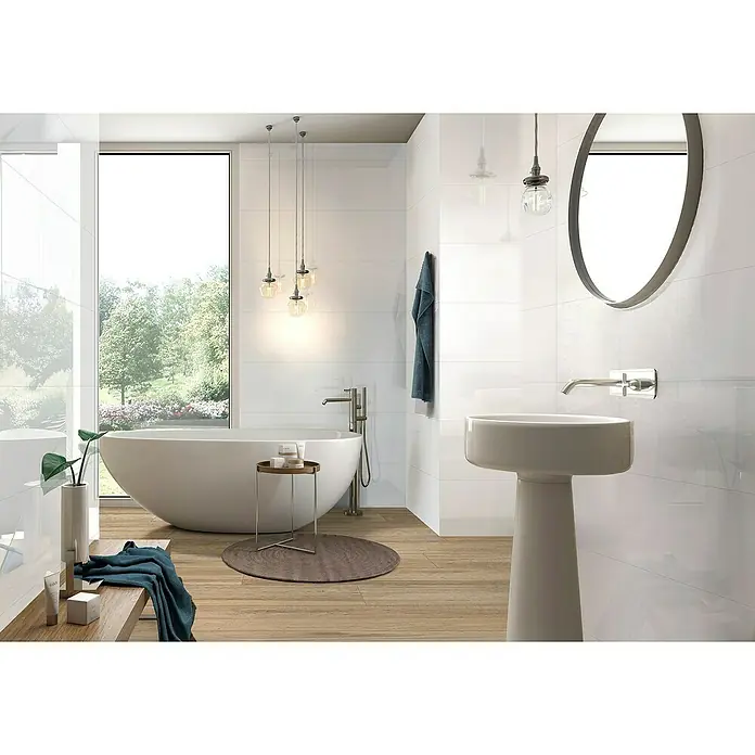 Revestimiento de pared Polar - 29,5 x 90 cm, Blanco, Brillante - Un baño moderno y luminoso con una bañera independiente, un lavabo de pedestal y pisos de madera para un toque lujoso.