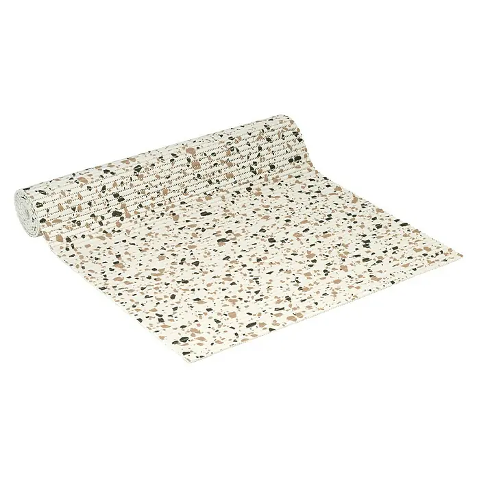 D-c-fix Bodenmatte Meterware Floor Comfort - Terrazzo, Breite: 65 cm - Ein cremefarbener Tischläufer mit Terrazzo-Muster, der aufgerollt liegt und eine moderne Ästhetik für den Tisch bietet.