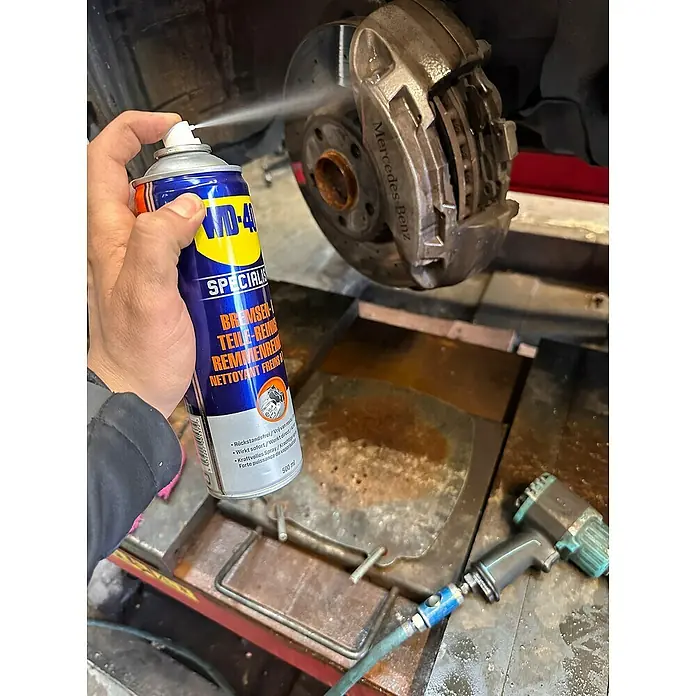 WD-40 Specialist Bremsen- & Teilereiniger Smart Straw - 500 ml - Detailaufnahme einer WD-40 Bremsenreiniger-Dose beim Reinigen einer Mercedes-Benz-Bremse.