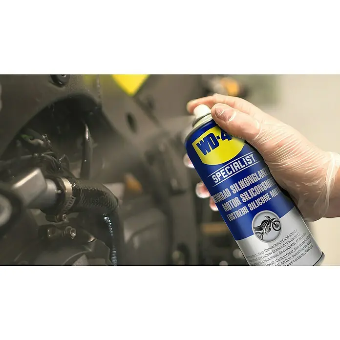 WD-40 Specialist Motorbike Silikon-Glanzspray Classic - 400 ml, Farblose Flüssigkeit - Eine Hand sprüht WD-40 Specialist Motorrad Silikonglanz auf ein Motorrad, um es zu pflegen und vor Witterungseinflüssen zu schützen.