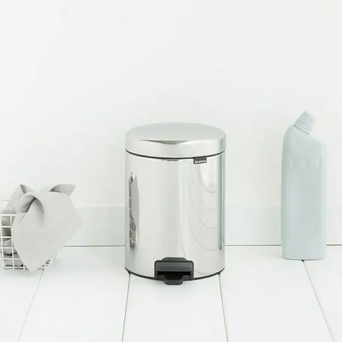 Proregal Treteimer Brabantia Klassischer Tretmülleimer mit Soft-Verschluss - 5 l, Metall, Edelstahl - Ein glänzender, zylindrischer Brabanita Treteimer aus Edelstahl steht neben einer grauen Reinigungsflasche auf einem weißen Boden.