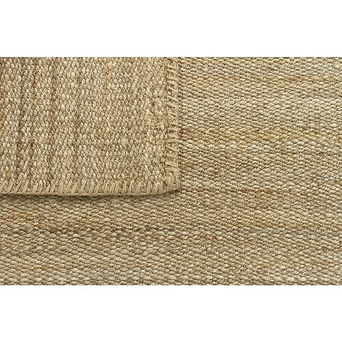 Alfombra de yute Córdoba - Natural, 360 x 220 cm, 100% yute - Primer plano de una alfombra de yute beige con una textura tejida y una puntada decorativa, resaltando la belleza natural y la calidad artesanal.