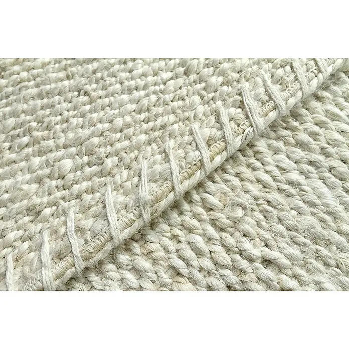 Alfombra de yute Córdoba - Blanco, 300 x 240 cm, 100% yute - Primer plano de una alfombra tejida con un borde levantado, mostrando la textura y el tejido de la alfombra.