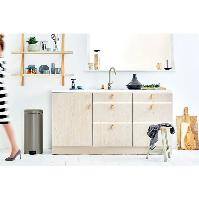 Proregal Treteimer Brabantia Klassischer Tretmülleimer mit Soft-Verschluss - 30 l, Metall, Platin - Dieses Bild zeigt einen grauen, zylinderförmigen Treteimer der Marke Brabantia in einer modernen Küche mit weißen Wänden und Holzfußboden.