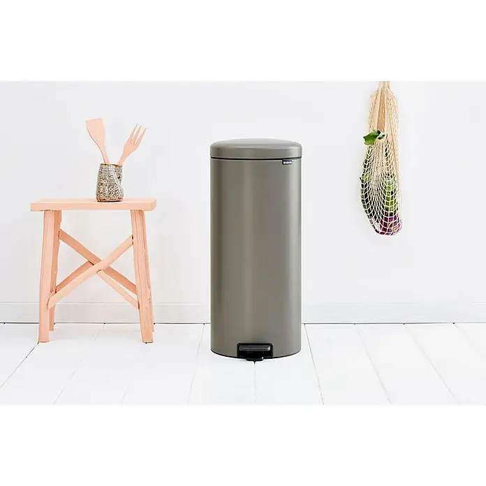 Proregal Treteimer Brabantia Klassischer Tretmülleimer mit Soft-Verschluss - 30 l, Metall, Platin - Ein freistehender, zylindrischer, grauer Mülleimer der Marke Brabantia mit einem Pedal zur einfachen Bedienung steht im Raum.