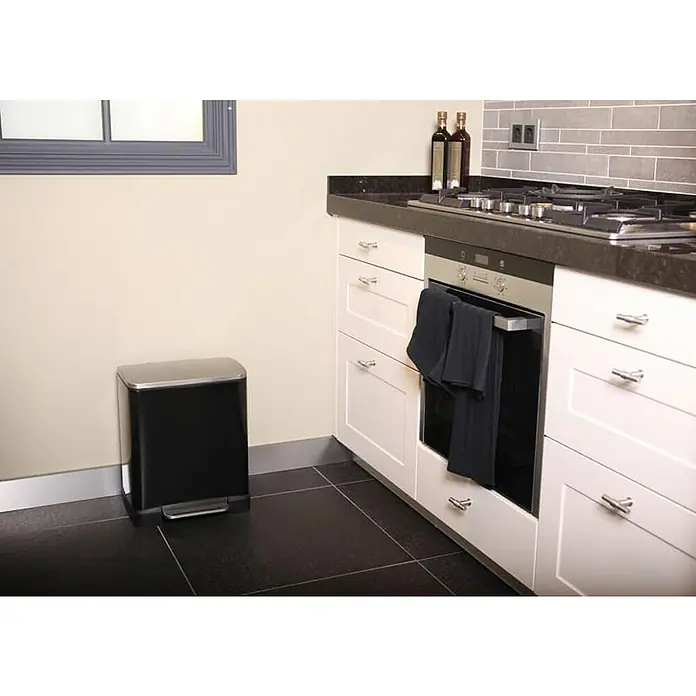 Proregal Treteimer Stilvoller rechteckiger Treteimer mit extra breitem Pedal - 19 l, Edelstahl, Schwarz, Deckel Edelstahl - Küchenszene mit einem schwarzen, rechteckigen Simplehuman-Treteimer aus Edelstahl, der neben weißen Küchenschränken steht.