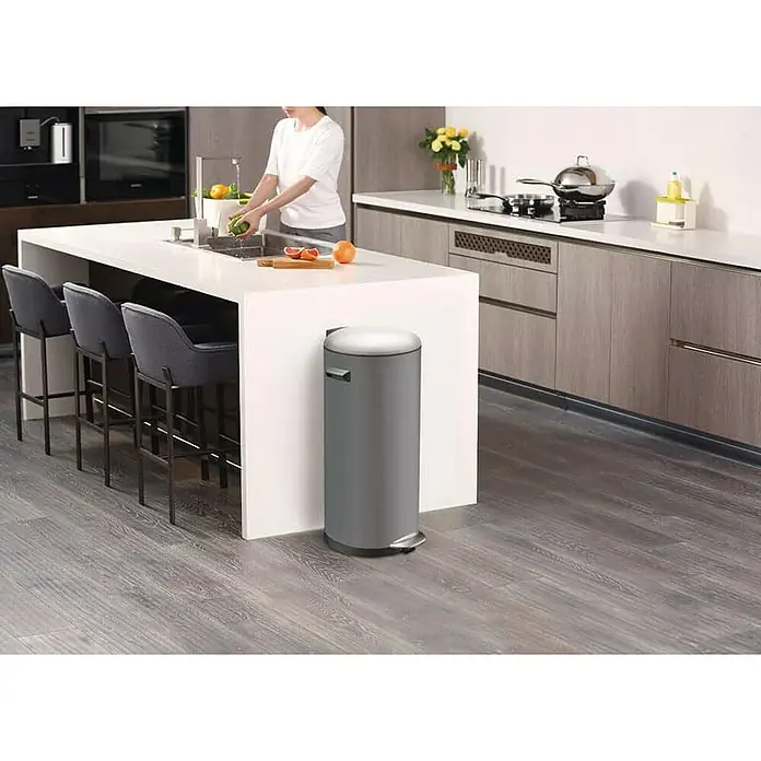 Proregal Treteimer Retro Treteimer mit markanten Griffen und Kugelkappe - 30 l, Kunststoff, Grau - Ein grauer, runder Treteimer steht in einer modernen Küche neben einer Kücheninsel, die mit Barhockern ausgestattet ist.