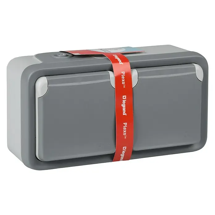 Legrand Plexo Enchufe para estancias con humedad doble - Gris, Alineación de los mecanismos: Vertical, Montaje en superficie, IP55 - La imagen muestra una caja de conexiones Plexo con el logo Legrand en una banda roja. La caja es gris con detalles en gris claro.