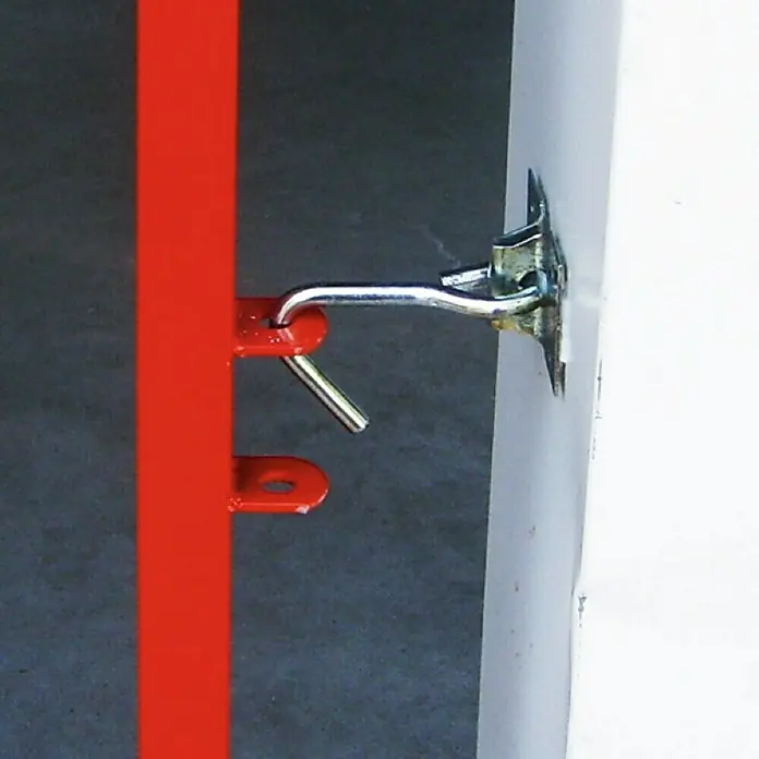Surtido de clips de sujeción - Robusto - Primer plano de un gancho de puerta simple, pero eficaz, en un poste pintado de rojo, cerrando de forma segura una puerta o una reja.