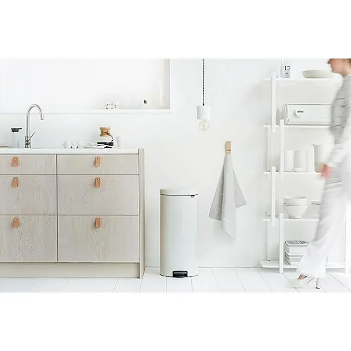 Proregal Treteimer Brabantia Klassischer Tretmülleimer mit Soft-Verschluss - 30 l, Metall, Weiß - Heller Küchenbereich mit modernem, zylindrischem Mülleimer neben einer minimalistischen Schrankzeile und einem Regal.