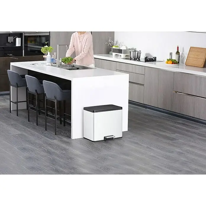 Proregal Treteimer - 29 l, Edelstahl, Weiß - Küchenszene mit einem eleganten, silberfarbenen Treteimer unter der Kücheninsel, der Funktionalität und modernes Design vereint.